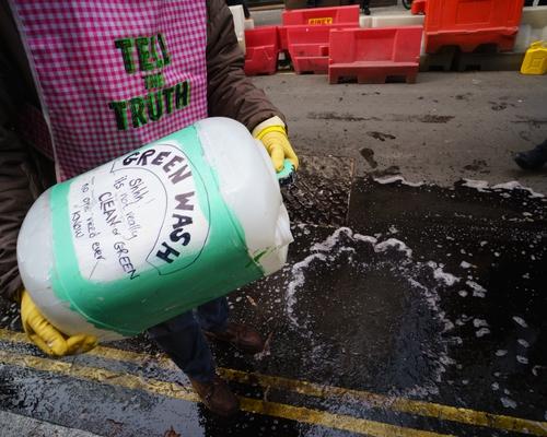 Person pouring jar labeled "greenwashing" onto the ground