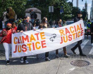 Climate Justice in the Global North: An Introduction - Image: Protesters holding banner that reads "Climate Justice, Racial Justice"