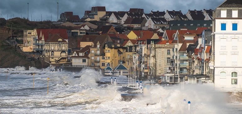 Waves crashing over a seawall on French coastline.